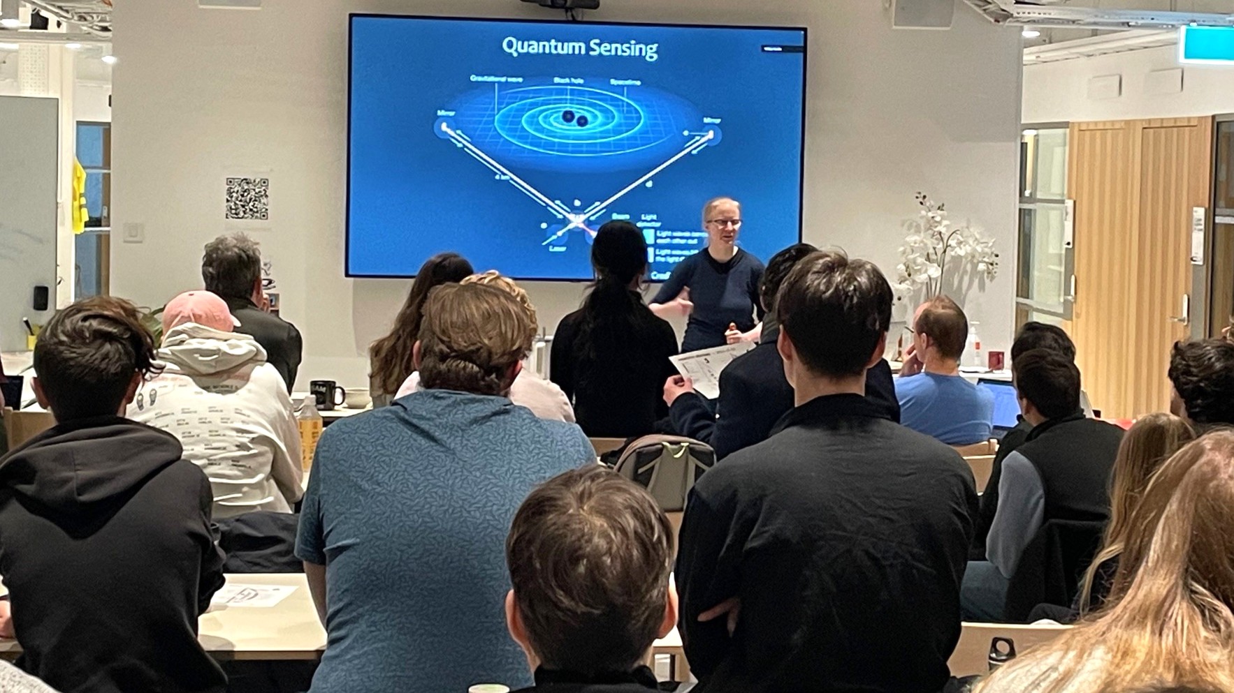 Students gathered watching an assistant professor present about quantum sensing on a big screen